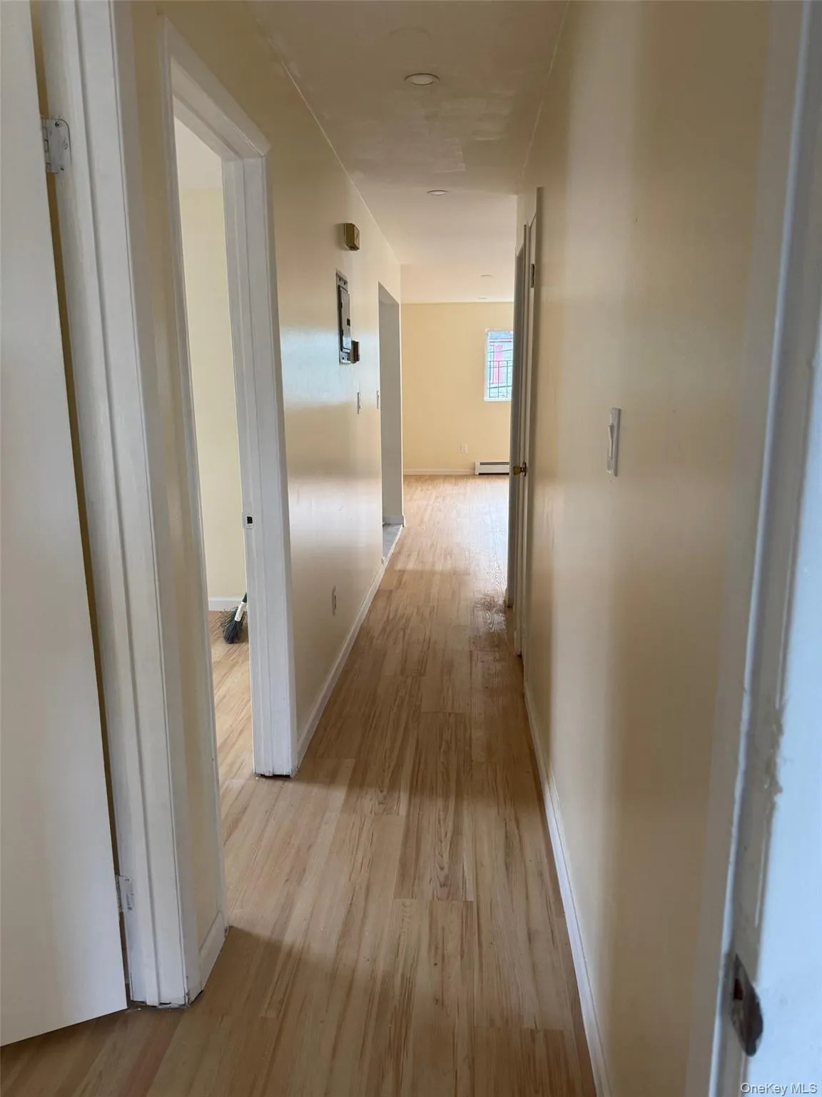 Corridor with light wood-style flooring and baseboards Corridor with light wood-style flooring and baseboards