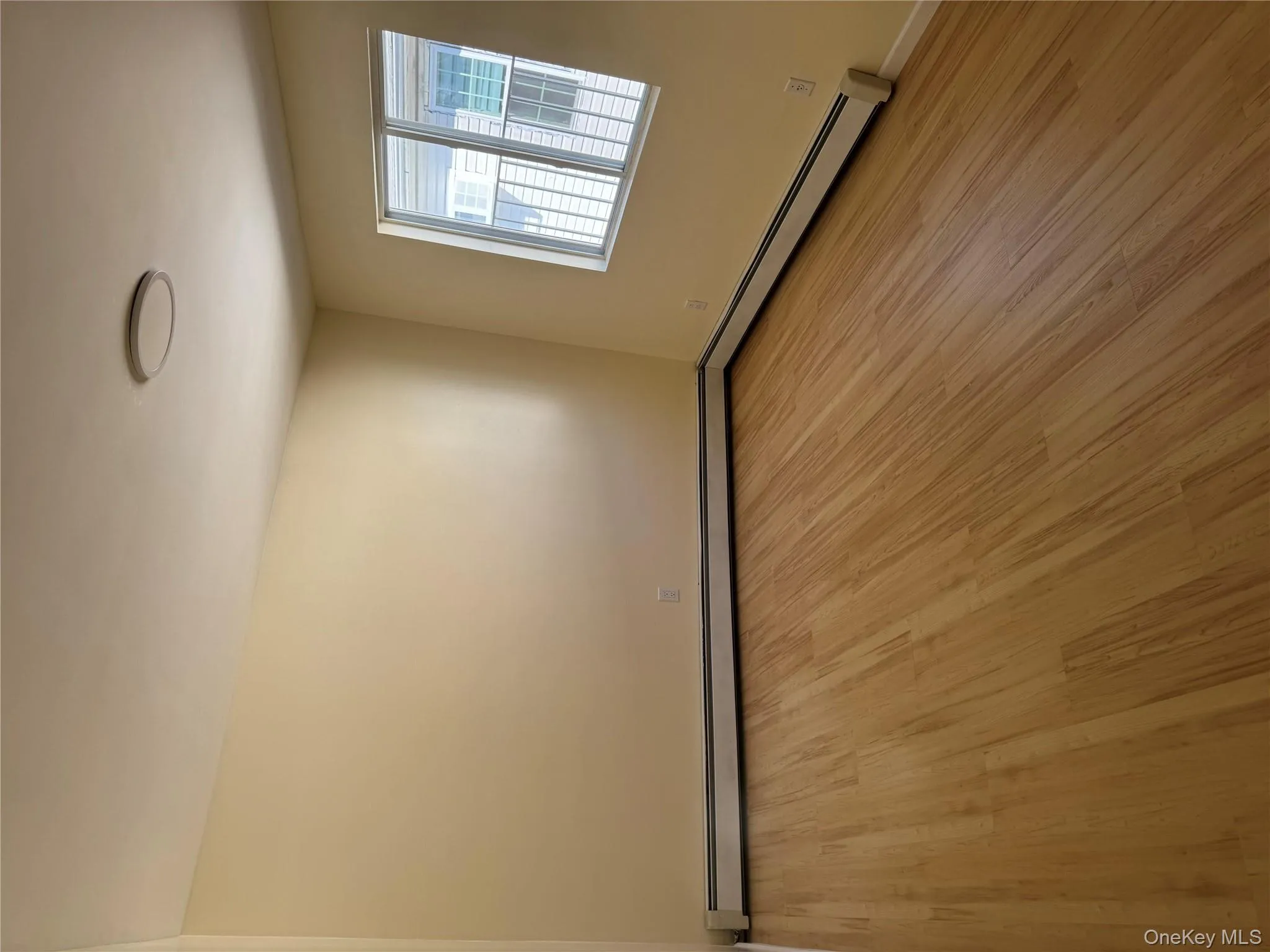 Unfurnished room featuring light wood-type flooring and a baseboard heating unit Unfurnished room featuring light wood-type flooring and a baseboard heating unit