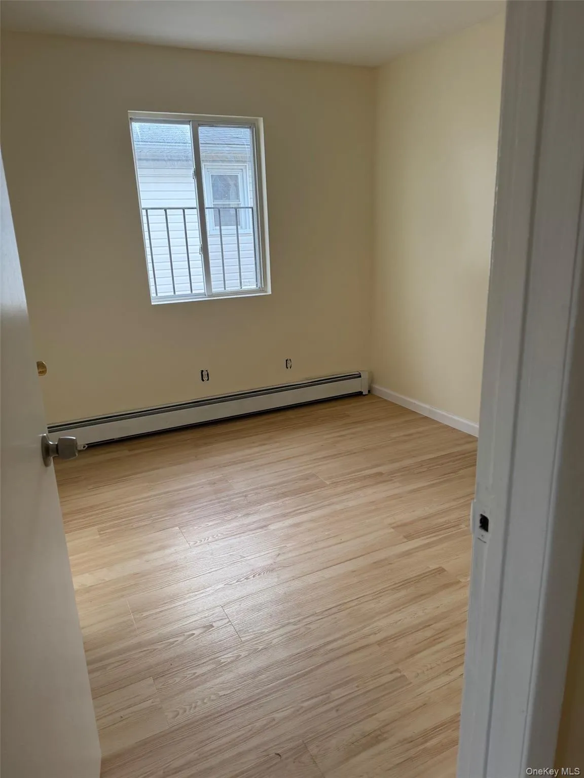 Spare room with a baseboard heating unit and light wood-style flooring Spare room with a baseboard heating unit and light wood-style flooring