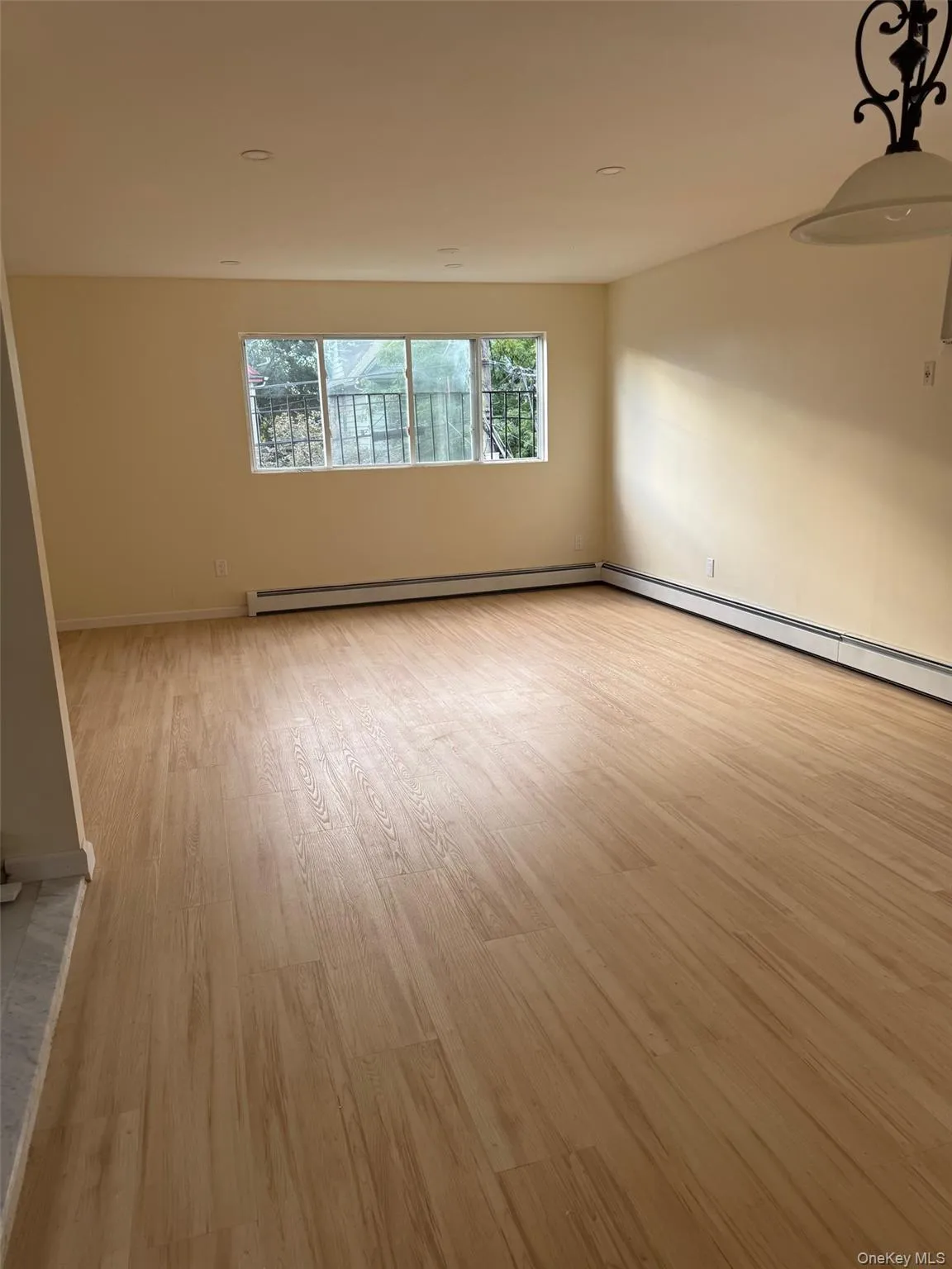 Spare room featuring light wood finished floors and a baseboard radiator Spare room featuring light wood finished floors and a baseboard radiator