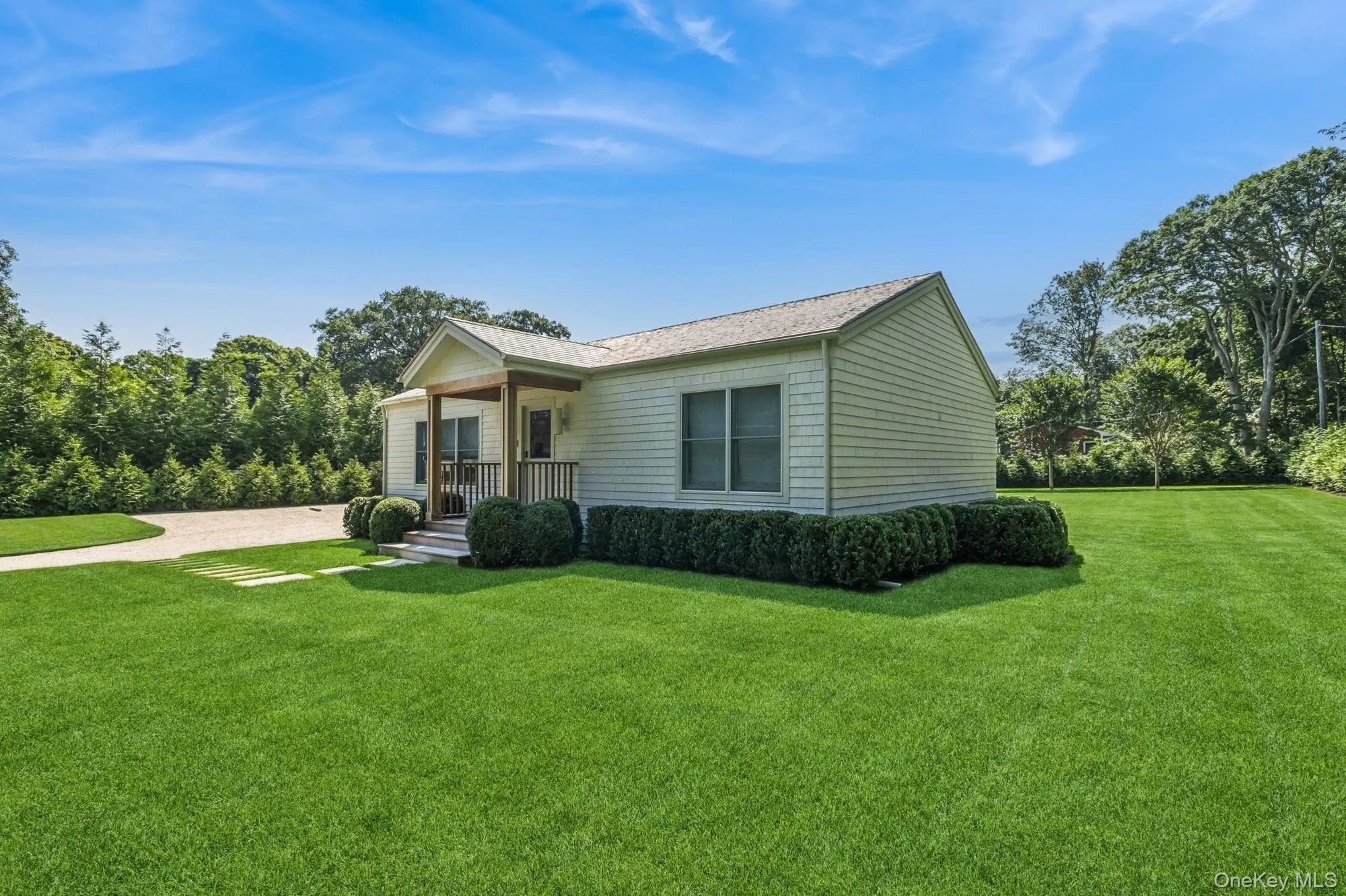 View of front facade with a front lawn, a porch, driveway, and roof with shingles View of front facade with a front lawn, a porch, driveway, and roof with shingles