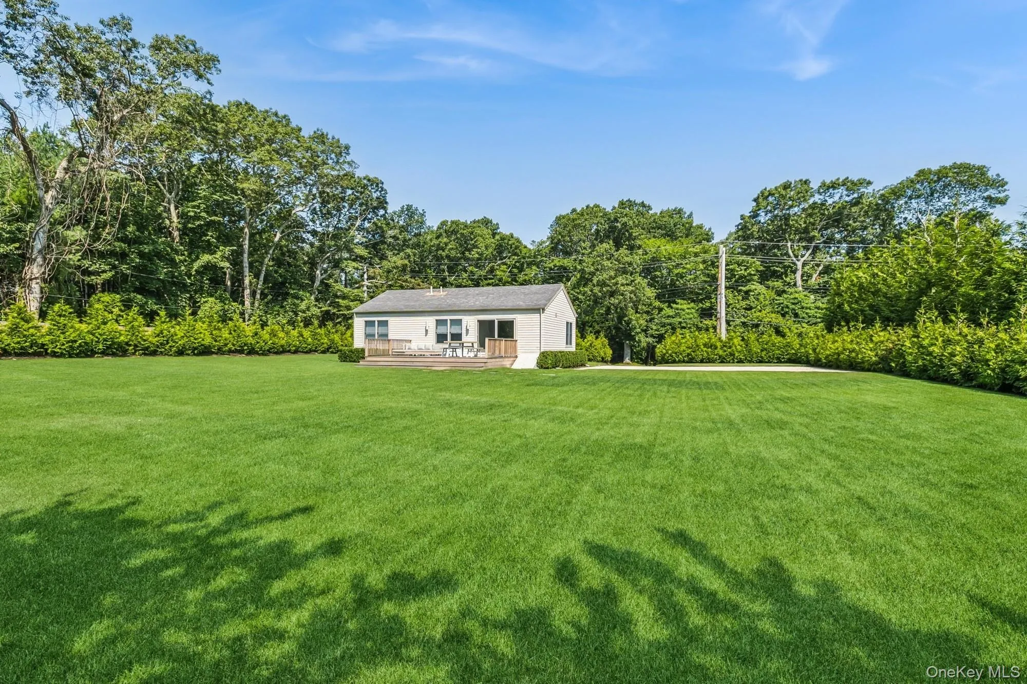 View of grassy yard with a wooden deck View of grassy yard with a wooden deck