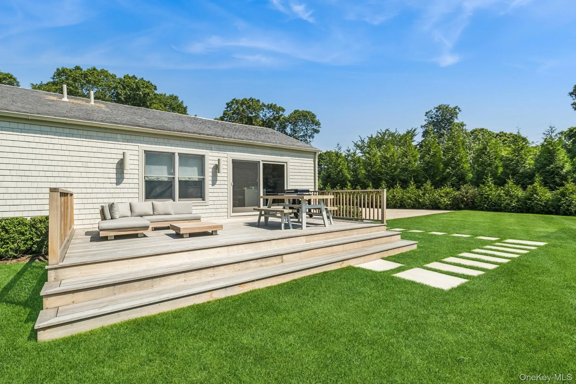 Rear view of house with a wooden deck, a yard, an outdoor living space, and view of wooded area Rear view of house with a wooden deck, a yard, an outdoor living space, and view of wooded area