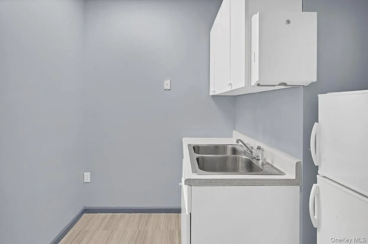 Laundry area featuring a sink and light wood-style flooring Laundry area featuring a sink and light wood-style flooring