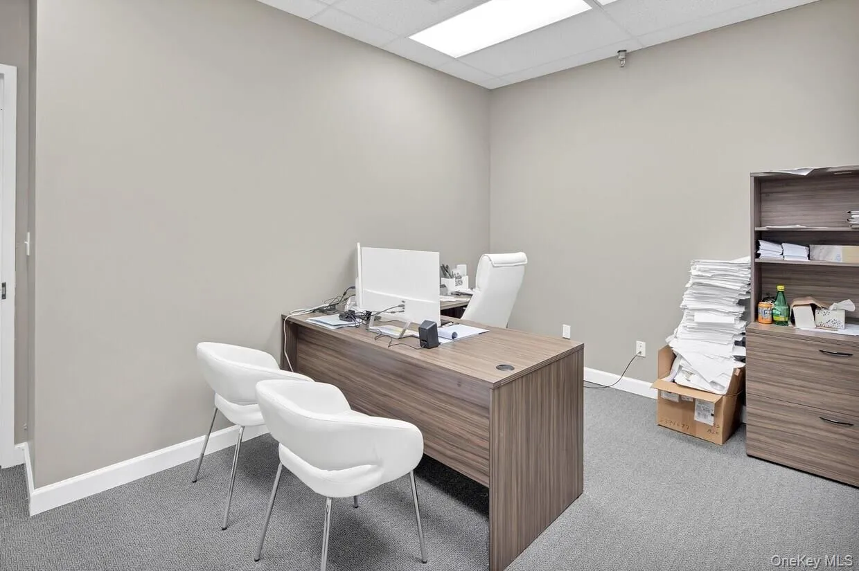 Home office featuring a paneled ceiling and carpet floors Home office featuring a paneled ceiling and carpet floors