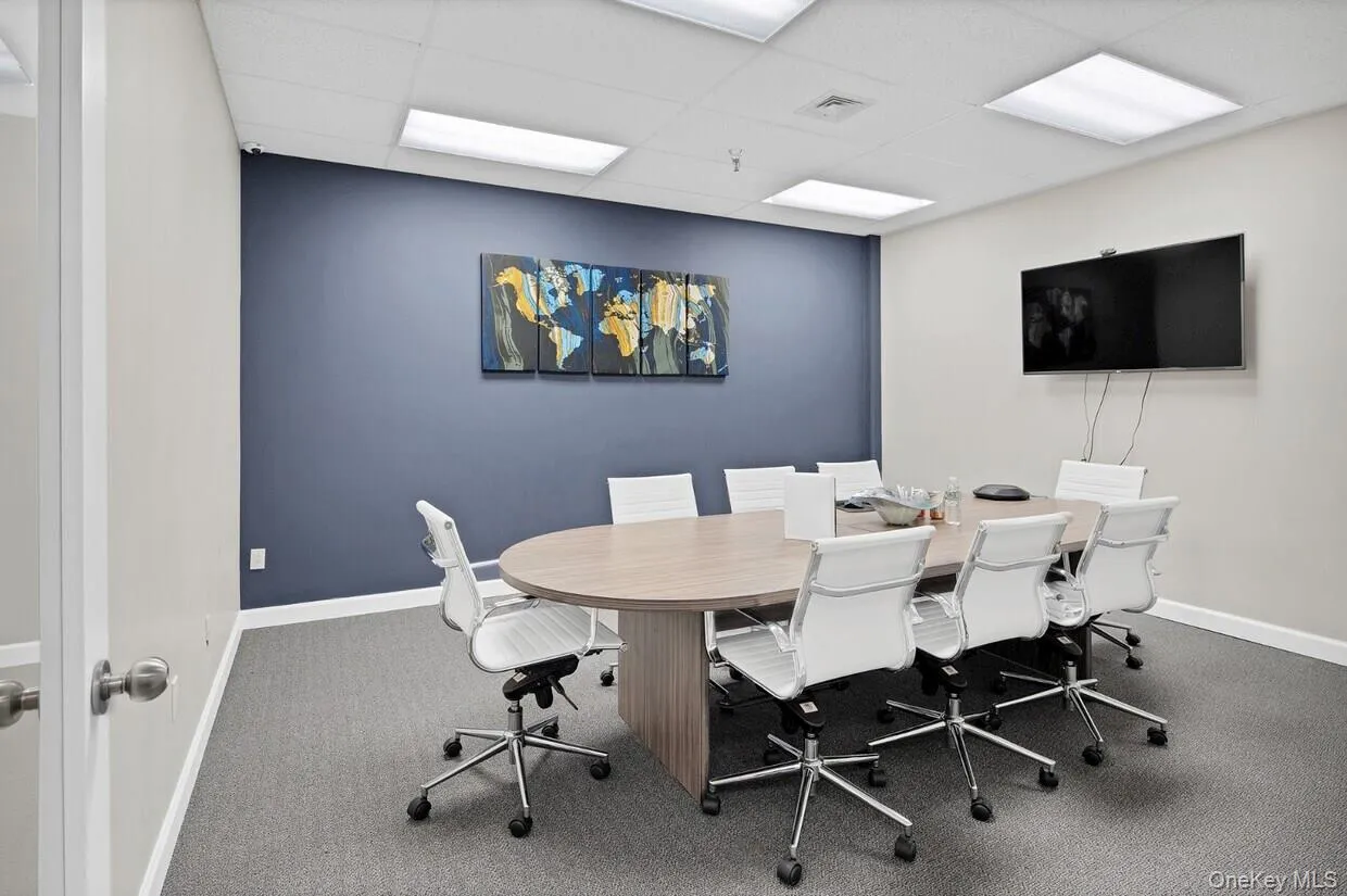 Office space with a paneled ceiling and carpet flooring Office space with a paneled ceiling and carpet flooring