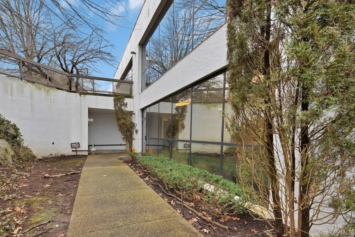View of property exterior featuring a sunroom and glass enclosure View of property exterior featuring a sunroom and glass enclosure