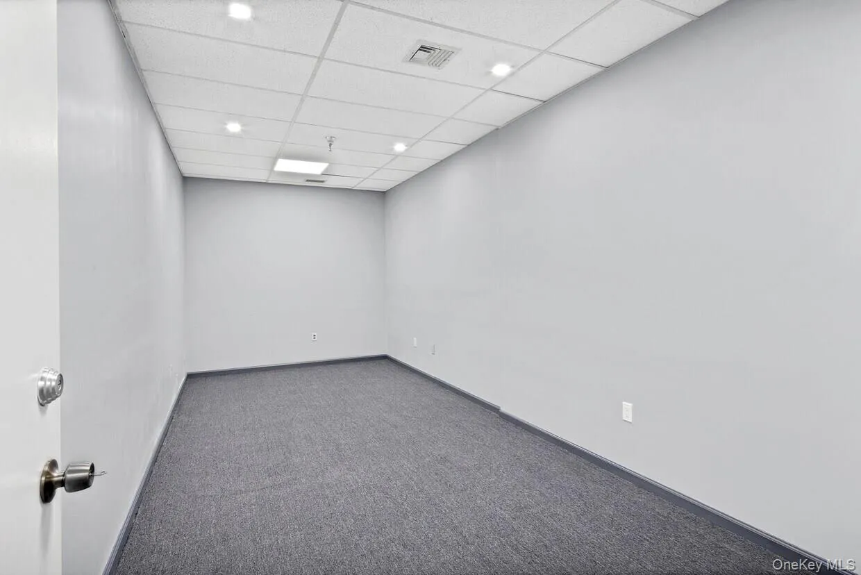 Carpeted empty room featuring a drop ceiling and recessed lighting Carpeted empty room featuring a drop ceiling and recessed lighting