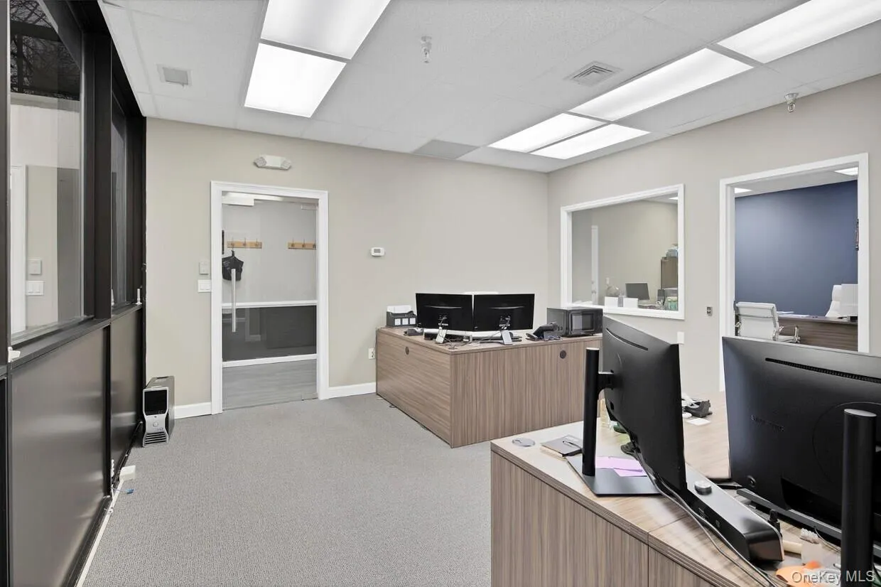 Office space featuring light colored carpet and a paneled ceiling Office space featuring light colored carpet and a paneled ceiling