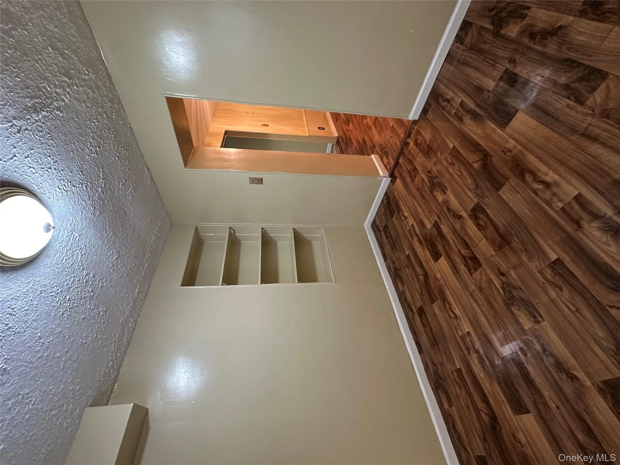 spare room featuring dark wood-style floors, built in features, and a textured ceiling spare room featuring dark wood-style floors, built in features, and a textured ceiling