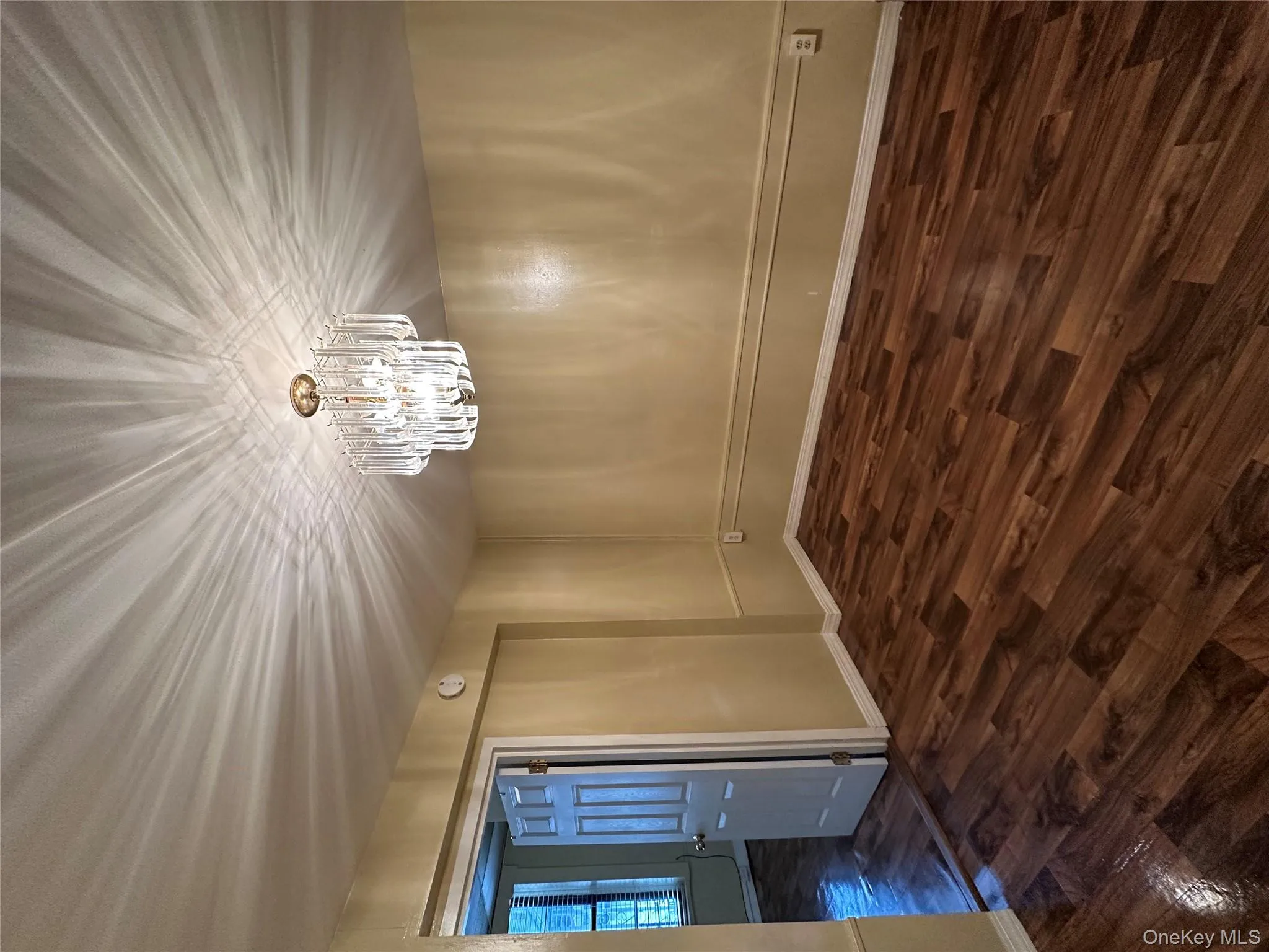 Spare room with dark wood-type flooring and a chandelier Spare room with dark wood-type flooring and a chandelier