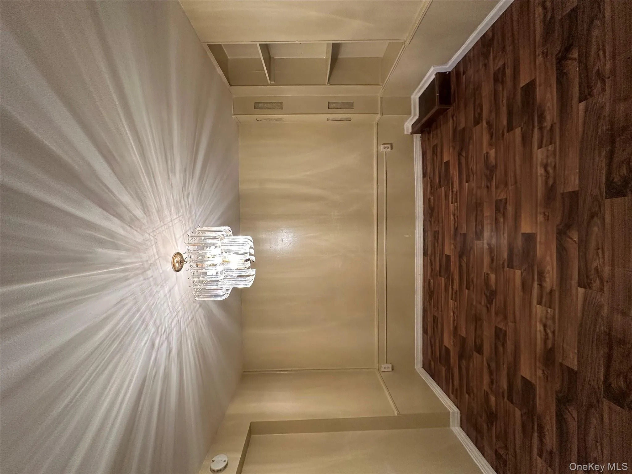 Living room featuring built in shelves, dark wood-style flooring, and a chandelier Living room featuring built in shelves, dark wood-style flooring, and a chandelier