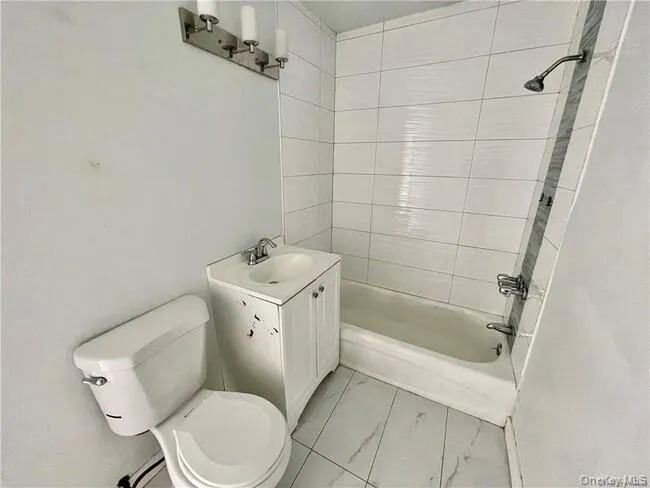 Full bathroom with shower / tub combination, vanity, and light marble finish flooring Full bathroom with shower / tub combination, vanity, and light marble finish flooring
