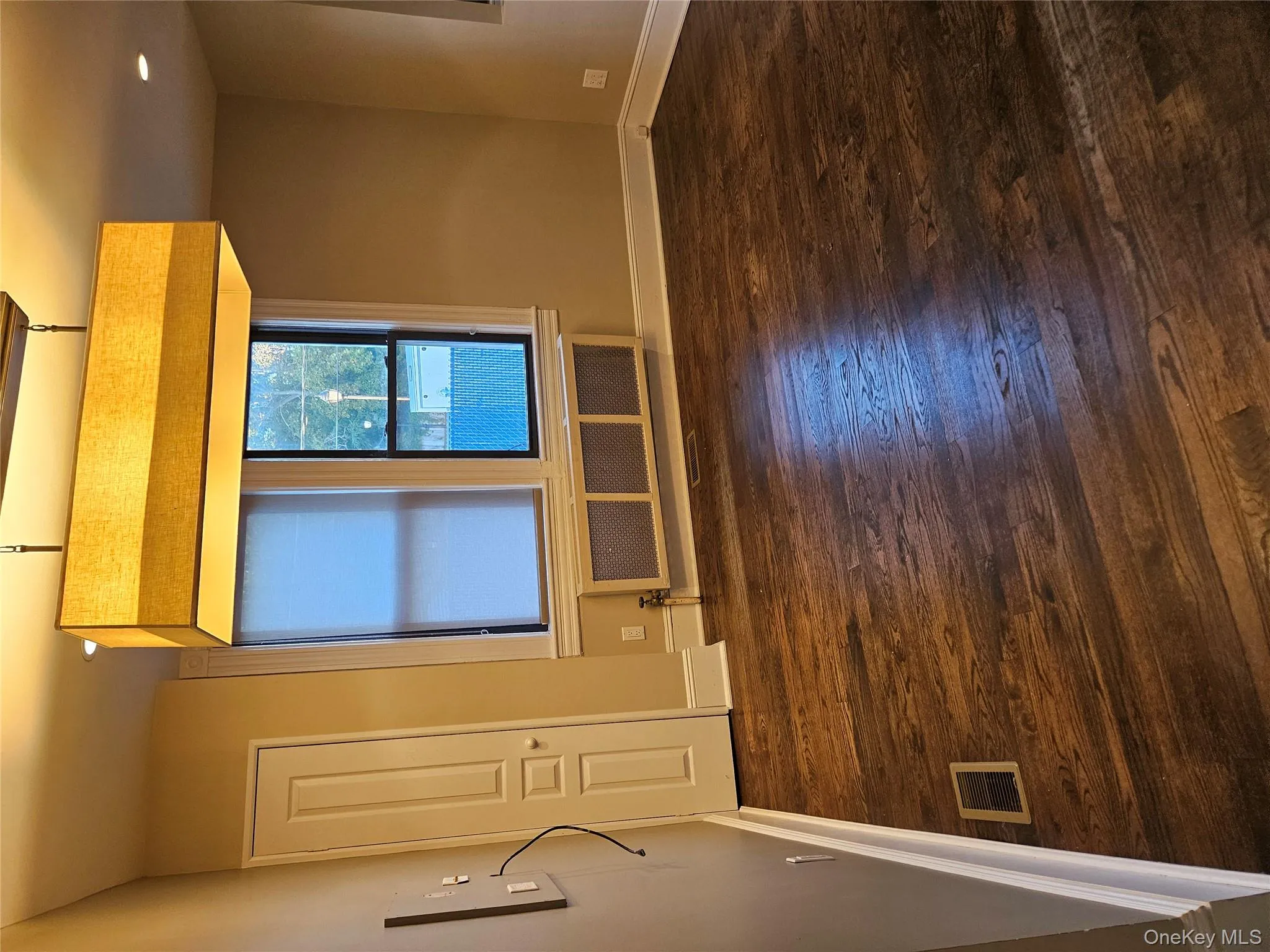 Unfurnished room with dark wood finished floors, radiator heating unit, and recessed lighting Unfurnished room with dark wood finished floors, radiator heating unit, and recessed lighting