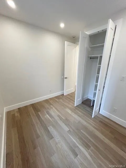 Unfurnished bedroom with light wood-style flooring, a closet, and recessed lighting Unfurnished bedroom with light wood-style flooring, a closet, and recessed lighting