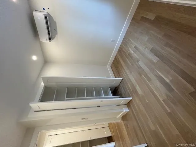 Unfurnished bedroom featuring light wood finished floors, recessed lighting, a wall mounted air conditioner, and a closet Unfurnished bedroom featuring light wood finished floors, recessed lighting, a wall mounted air conditioner, and a closet