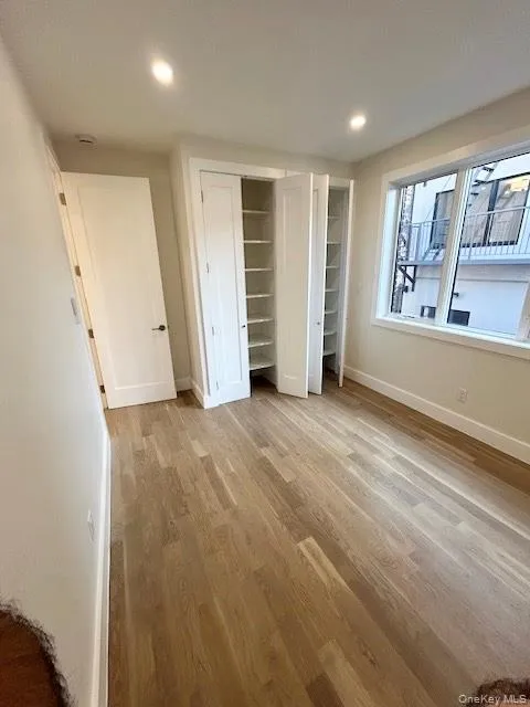 Unfurnished bedroom with multiple closets, light wood-style flooring, and recessed lighting Unfurnished bedroom with multiple closets, light wood-style flooring, and recessed lighting