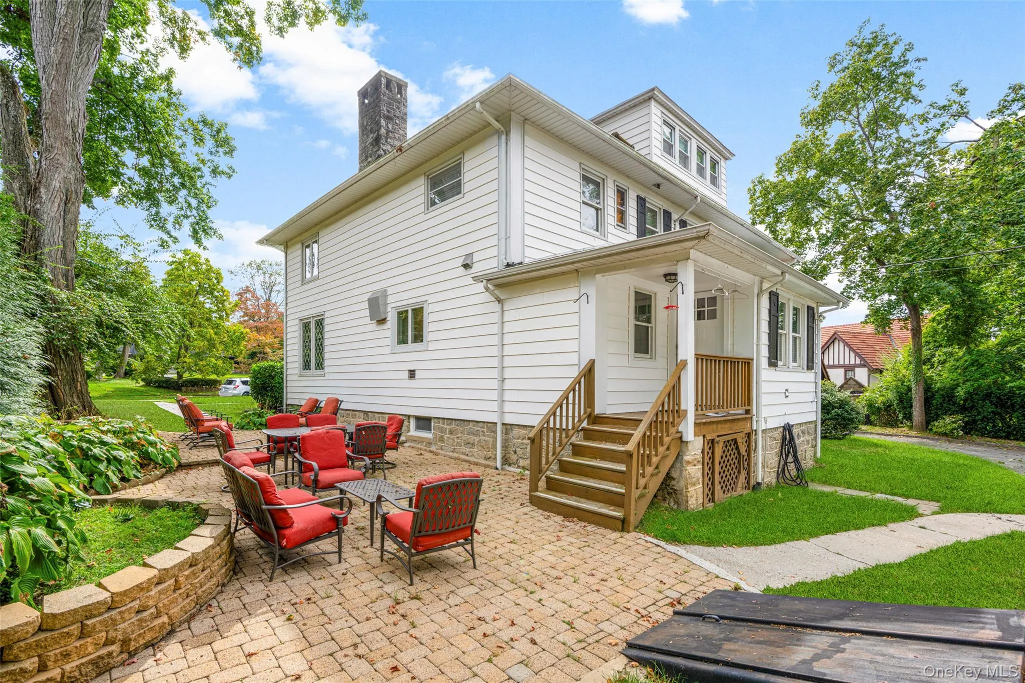 Back of property featuring an outdoor hangout area, a patio area, a chimney, and a lawn Back of property featuring an outdoor hangout area, a patio area, a chimney, and a lawn