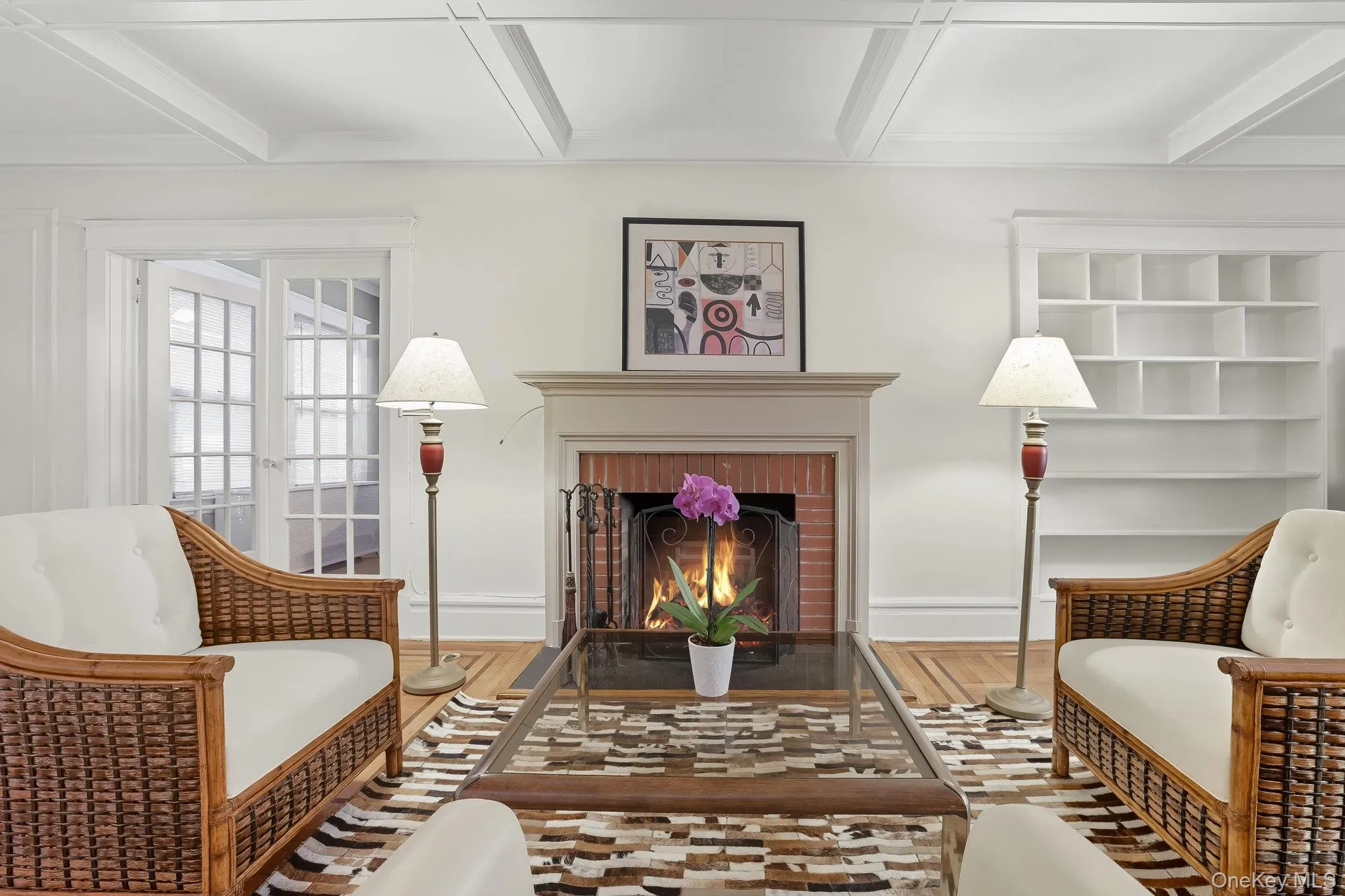 Living area featuring high coffered ceiling with brick fireplace and wood finished floors Living area featuring high coffered ceiling with brick fireplace and wood finished floors