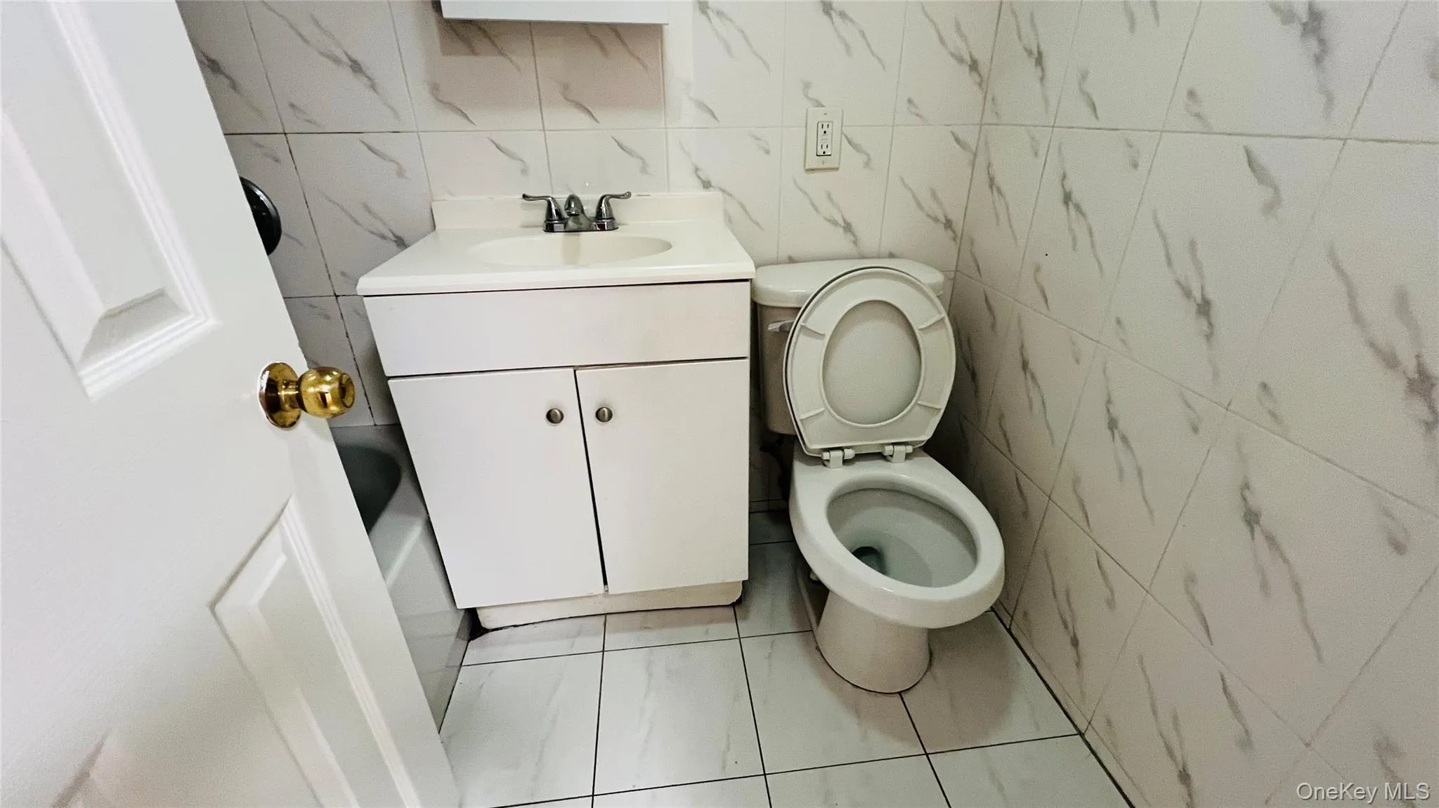 Bathroom with tile walls, vanity, and light tile patterned floors Bathroom with tile walls, vanity, and light tile patterned floors