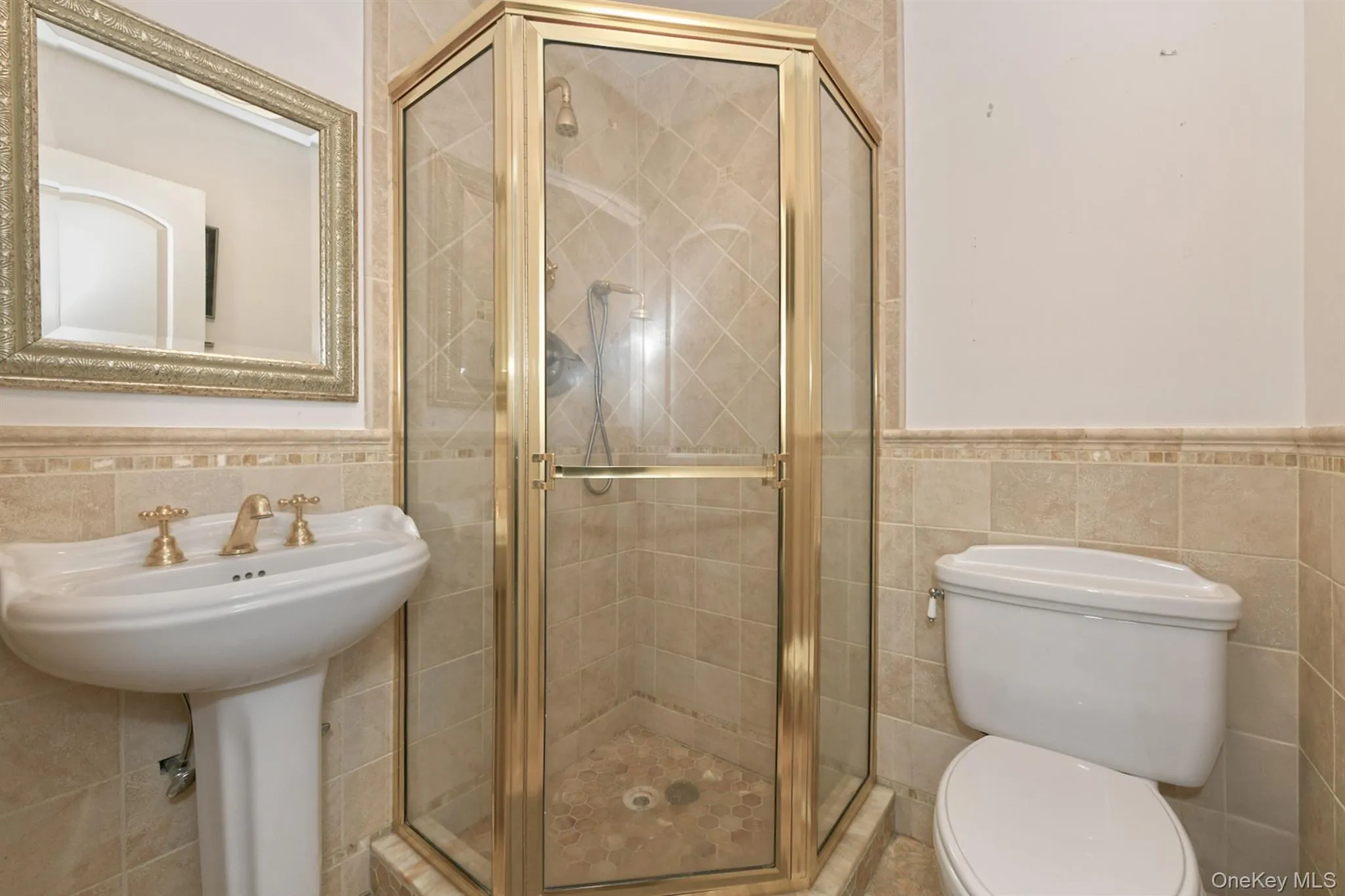 Bathroom with tile walls, wainscoting, and a shower stall Bathroom with tile walls, wainscoting, and a shower stall