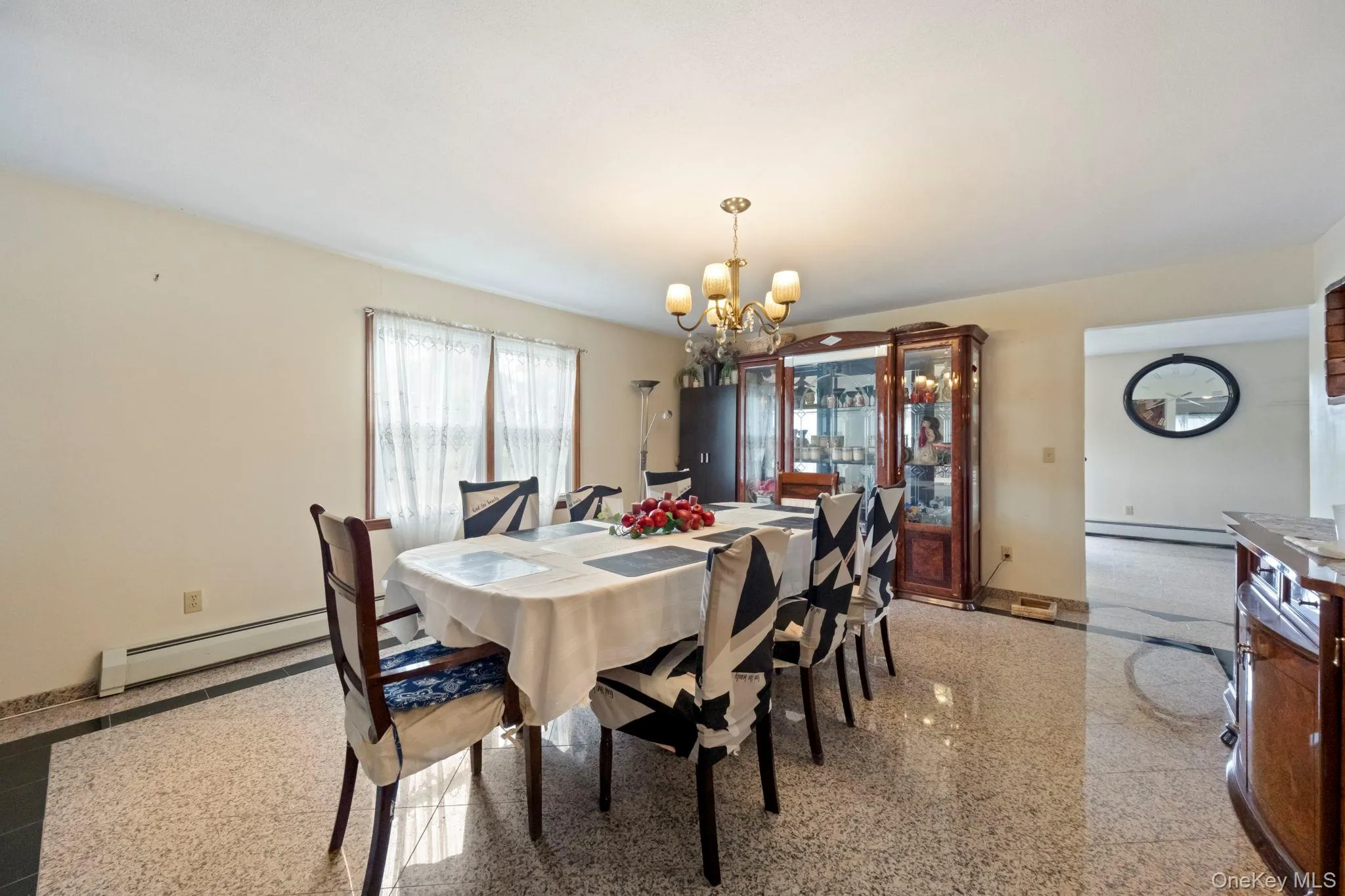 Dining space featuring granite floors, a chandelier, and a baseboard radiator Dining space featuring granite floors, a chandelier, and a baseboard radiator