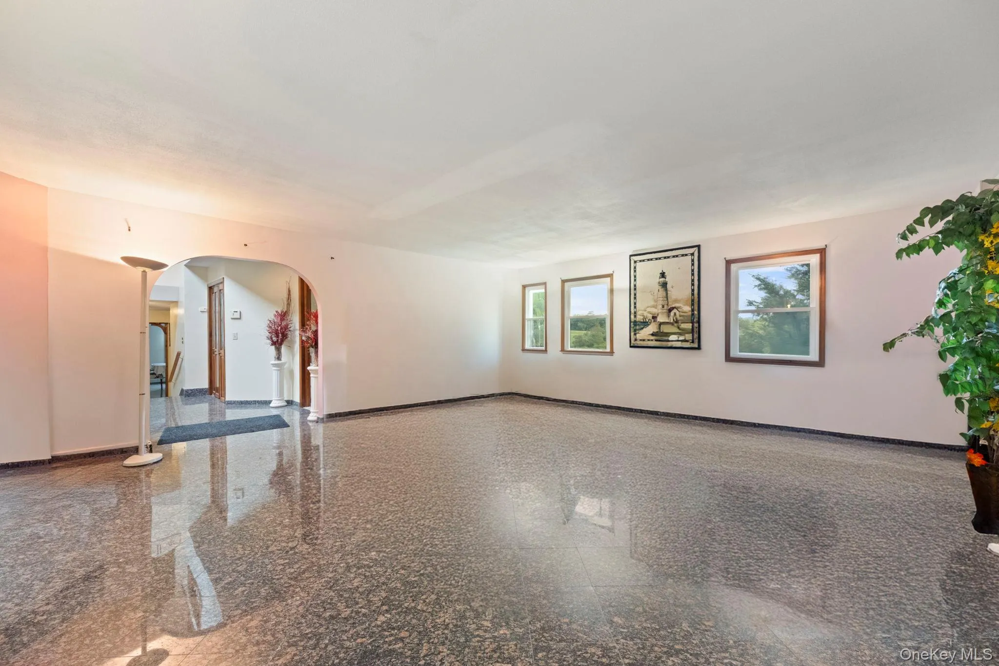 Spare room featuring granite floors and arched walkways Spare room featuring granite floors and arched walkways
