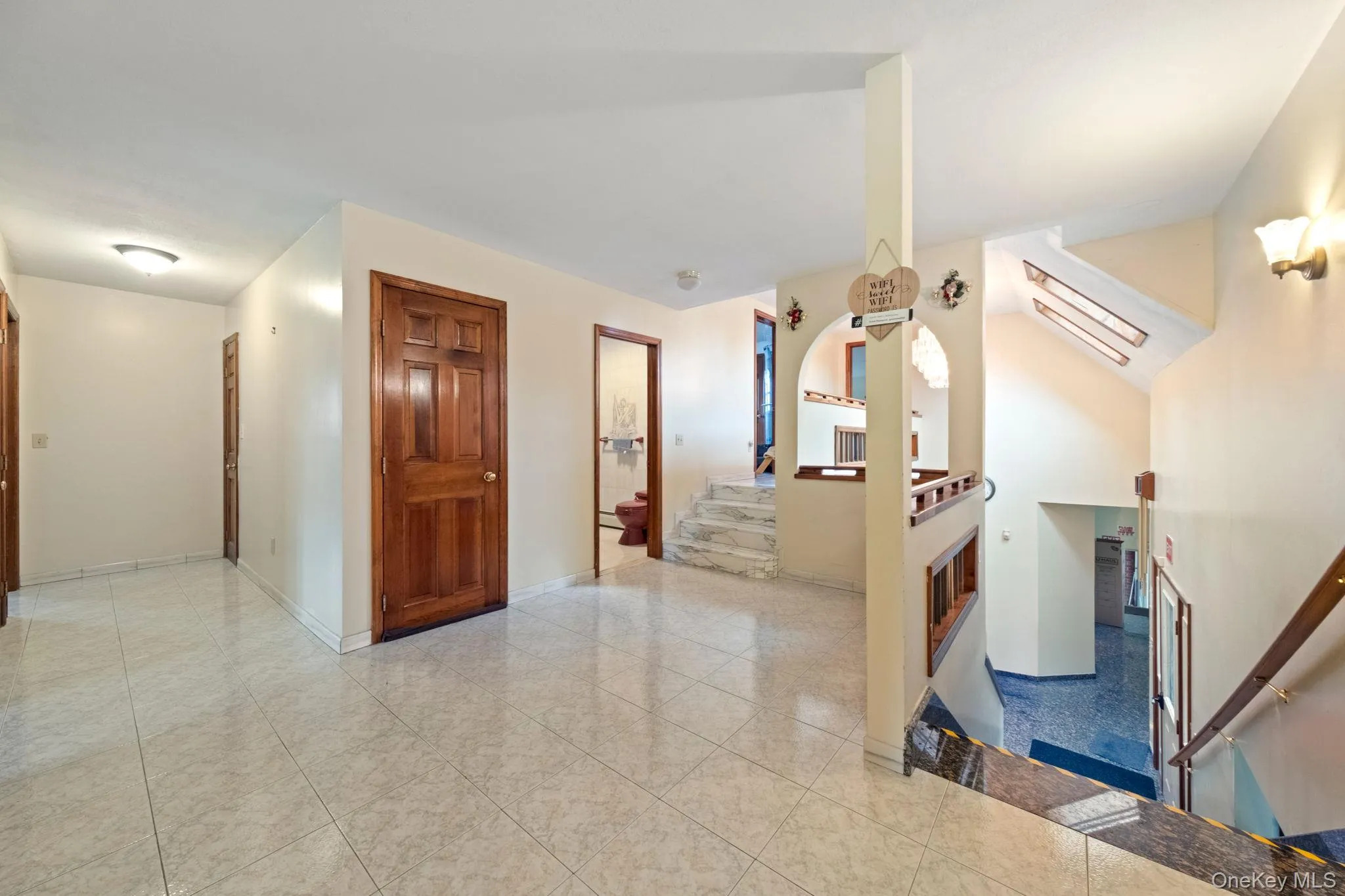 Hall featuring stairway and light tile patterned flooring Hall featuring stairway and light tile patterned flooring