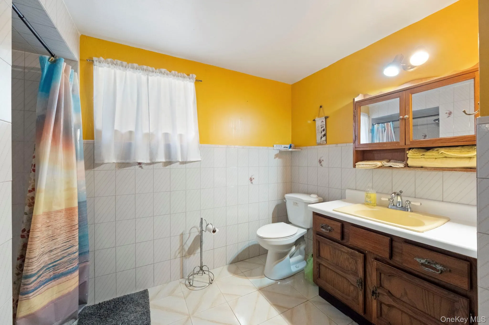 Bathroom with light tile patterned floors, vanity, and tile walls Bathroom with light tile patterned floors, vanity, and tile walls