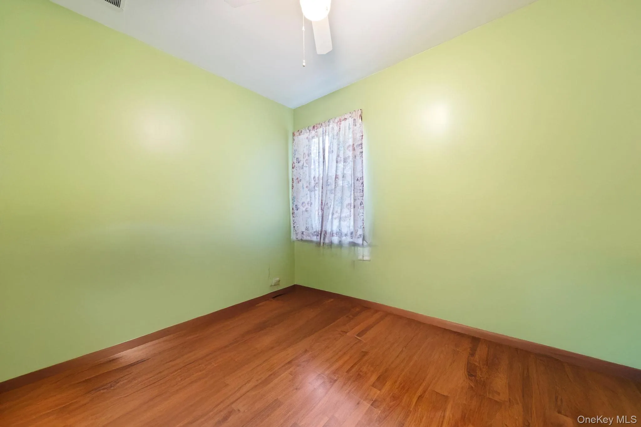 Unfurnished room featuring wood finished floors and ceiling fan Unfurnished room featuring wood finished floors and ceiling fan