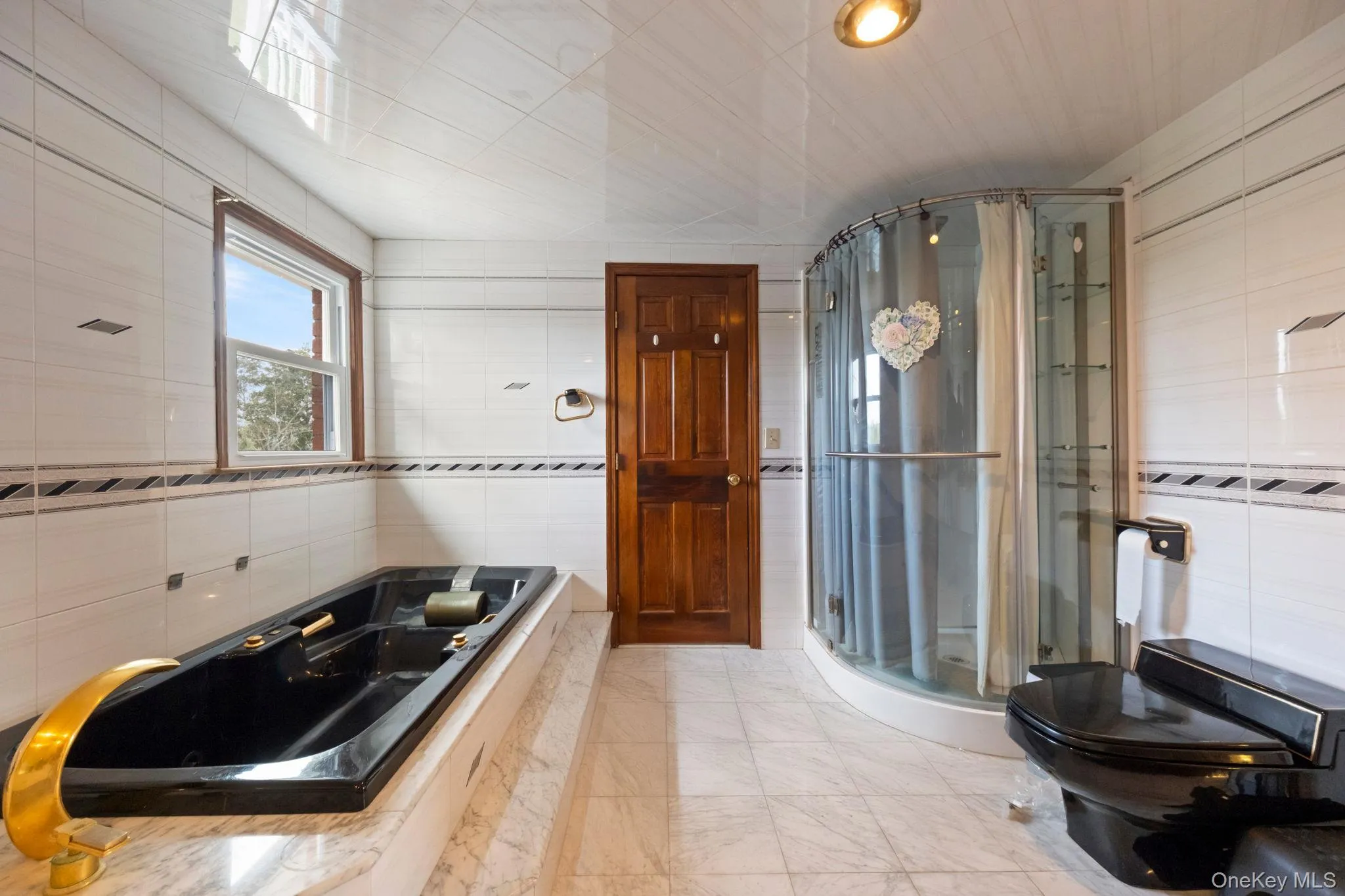 Bathroom with tile walls, a shower stall, and a tub with jets Bathroom with tile walls, a shower stall, and a tub with jets