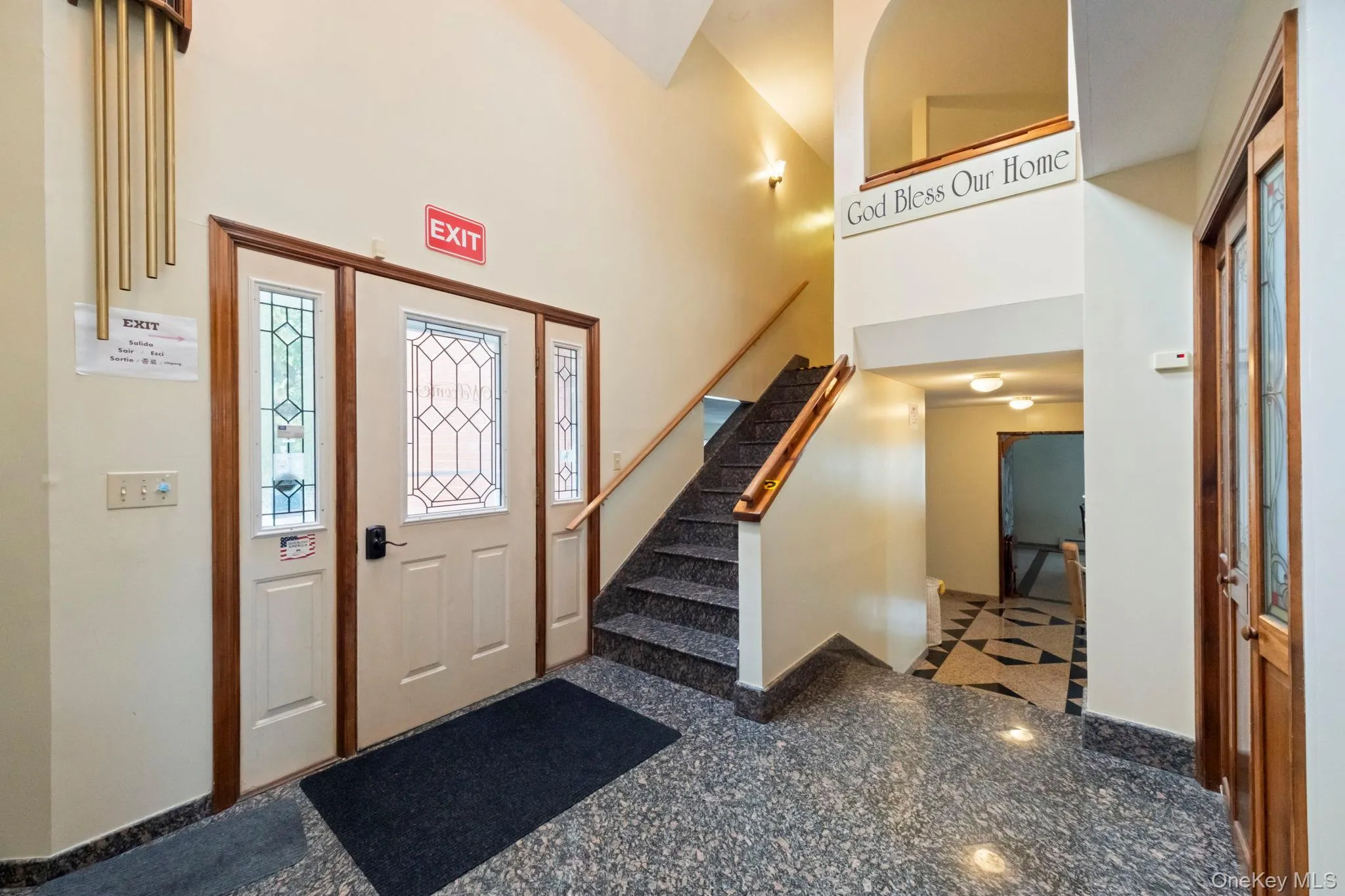 Foyer featuring granite tiled floors, a high ceiling, and stairs Foyer featuring granite tiled floors, a high ceiling, and stairs