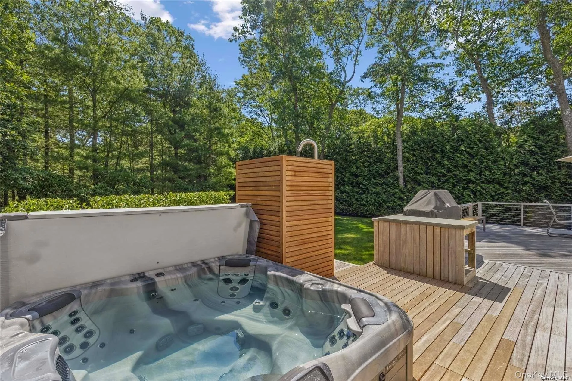 Wooden terrace with an outdoor hot tub and grilling area Wooden terrace with an outdoor hot tub and grilling area