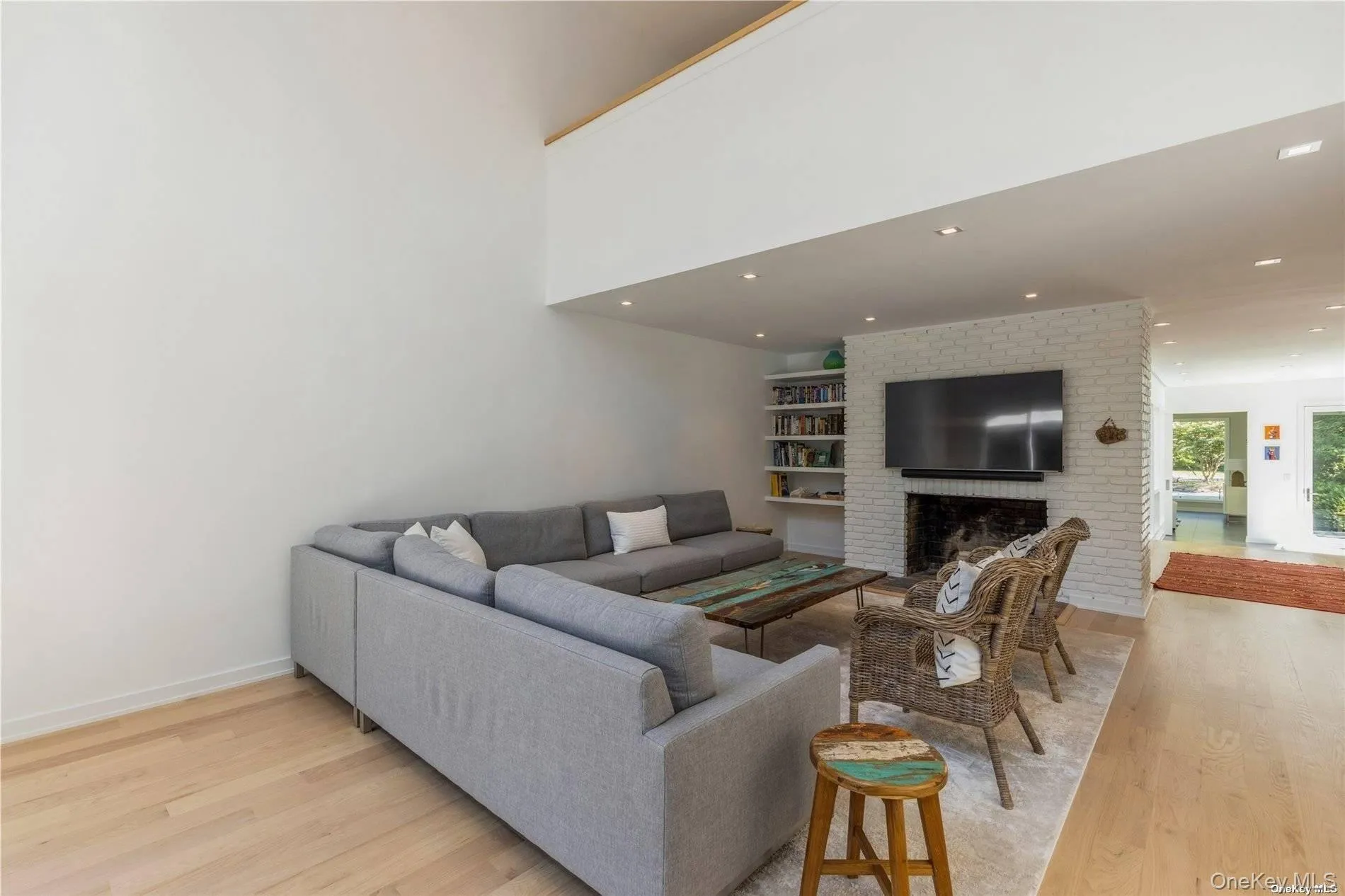 Living room featuring light wood-style floors, a fireplace, recessed lighting, and built in shelves Living room featuring light wood-style floors, a fireplace, recessed lighting, and built in shelves