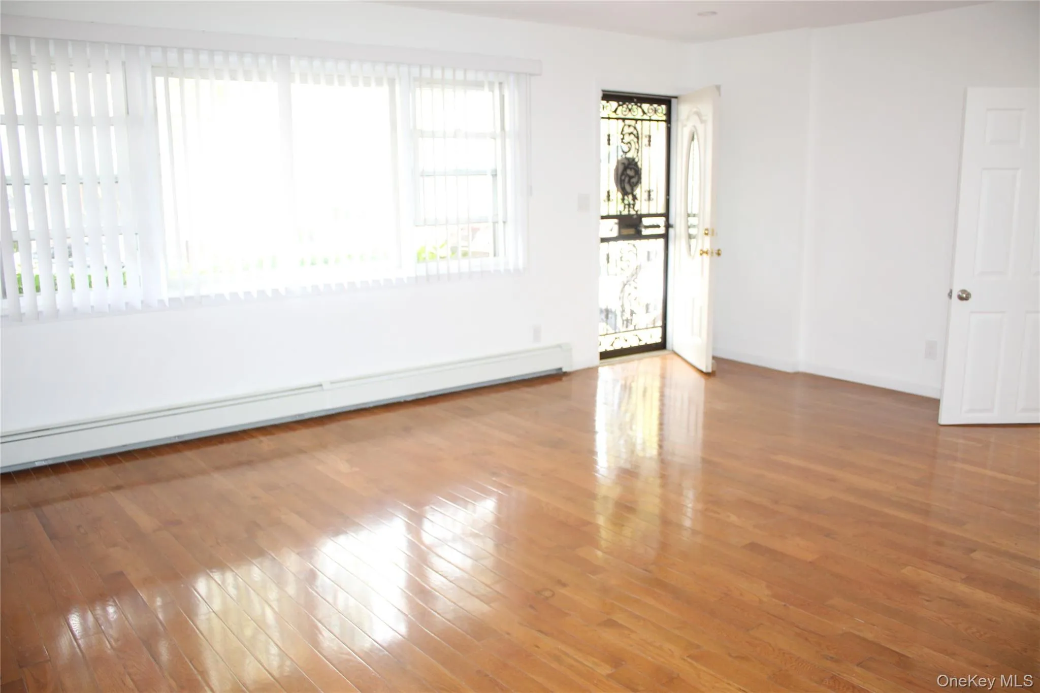 Empty room with a baseboard heating unit and light wood-style floors Empty room with a baseboard heating unit and light wood-style floors