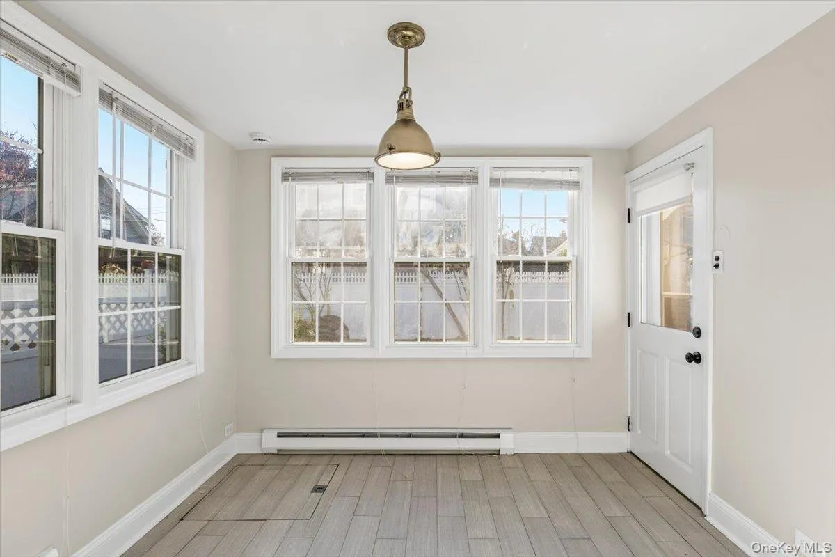 Unfurnished dining area featuring a baseboard radiator and light wood-style flooring Unfurnished dining area featuring a baseboard radiator and light wood-style flooring