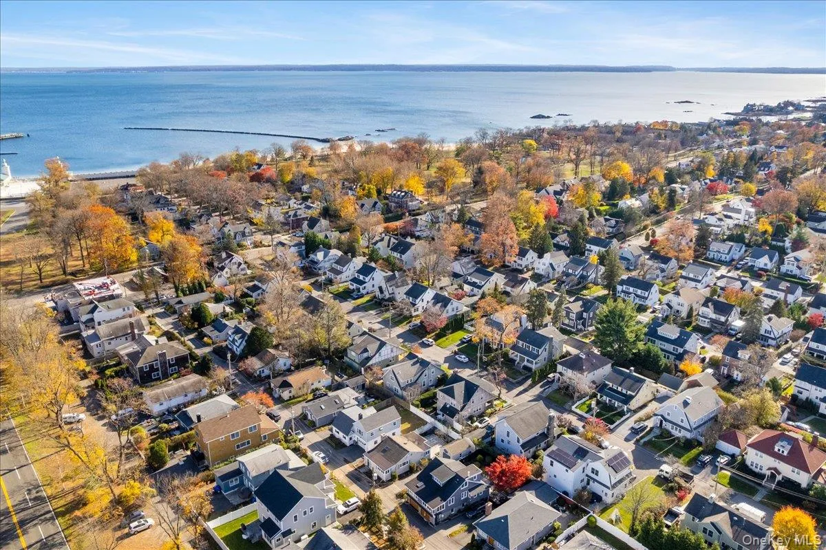 Aerial view of property and surrounding area featuring nearby suburban area and a nearby body of water Aerial view of property and surrounding area featuring nearby suburban area and a nearby body of water