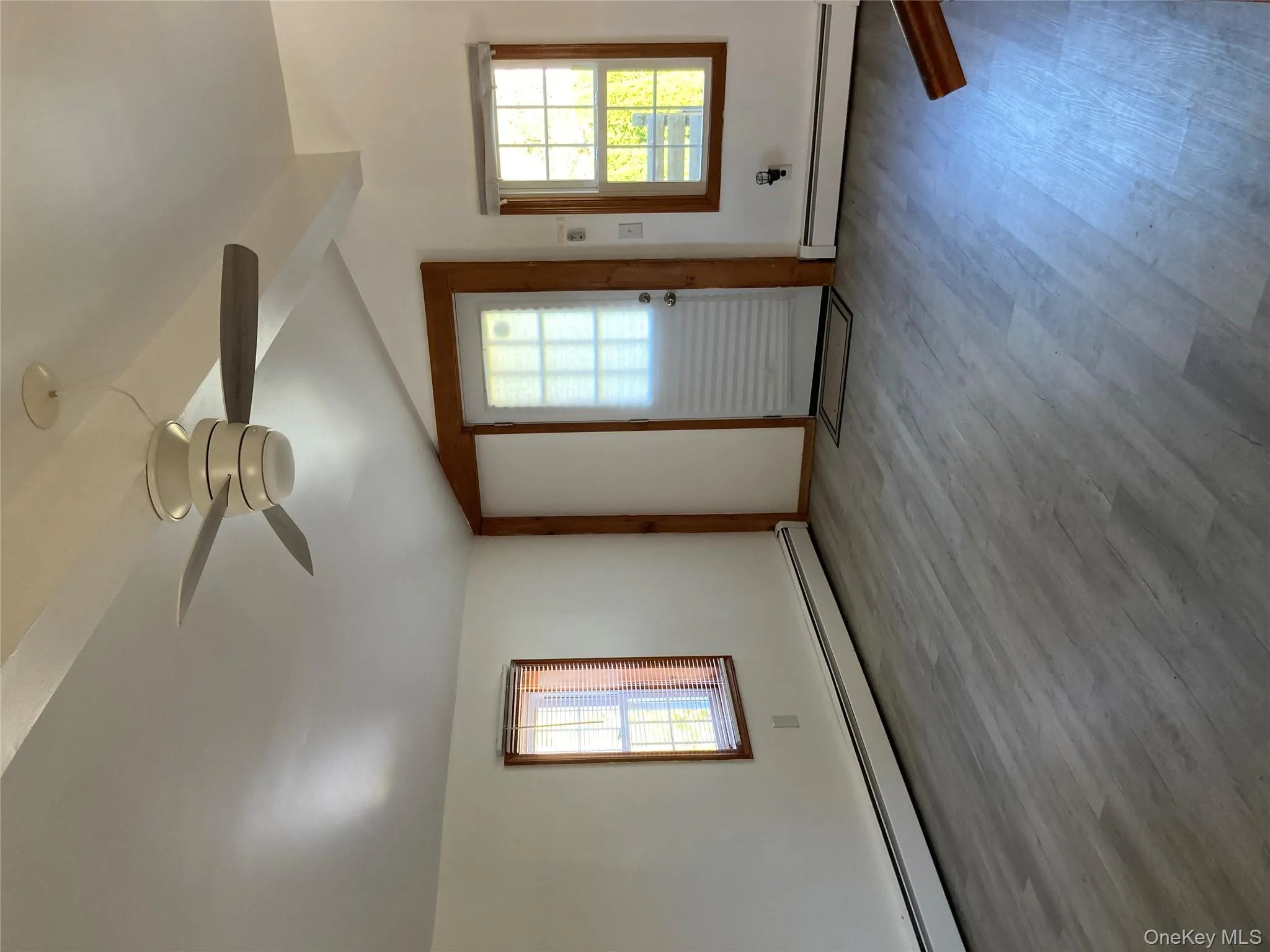 Spare room with a baseboard heating unit, healthy amount of natural light, and wood finished floors Spare room with a baseboard heating unit, healthy amount of natural light, and wood finished floors