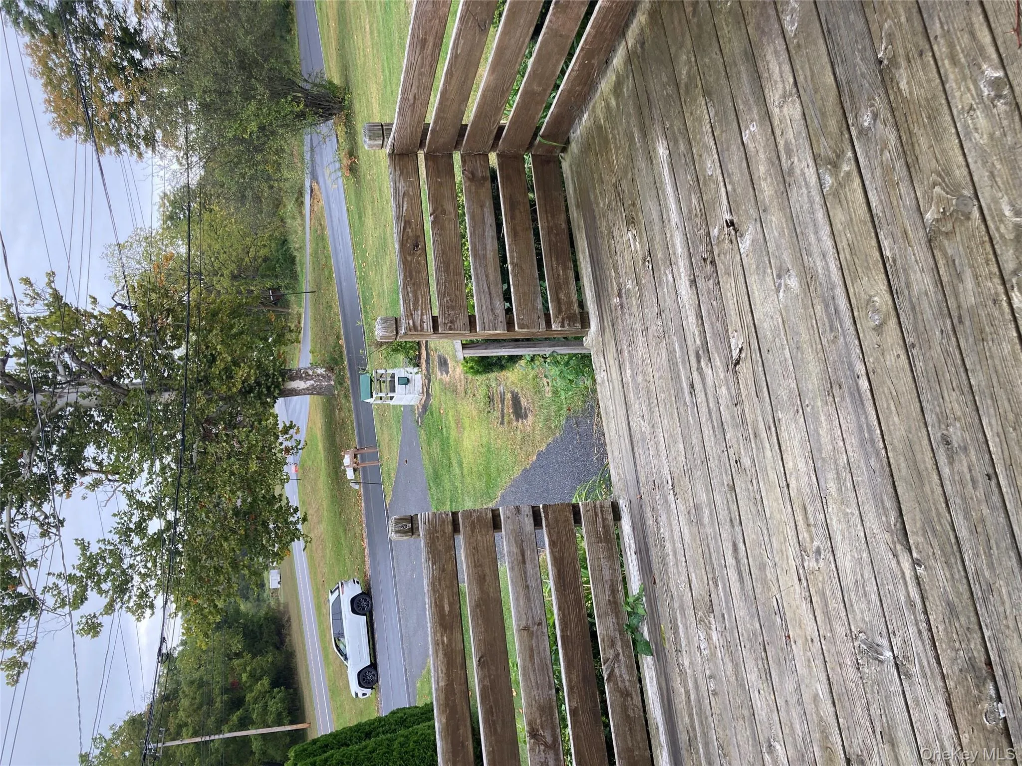 Wooden terrace featuring a lawn Wooden terrace featuring a lawn