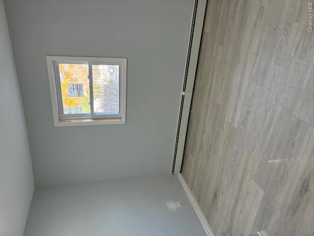 Unfurnished room featuring light wood-type flooring and baseboard heating Unfurnished room featuring light wood-type flooring and baseboard heating