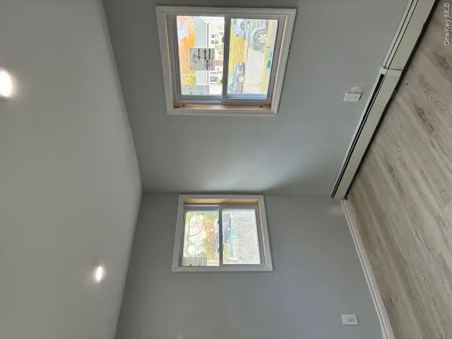 Unfurnished room featuring a baseboard heating unit, recessed lighting, light wood-type flooring, and healthy amount of natural light Unfurnished room featuring a baseboard heating unit, recessed lighting, light wood-type flooring, and healthy amount of natural light