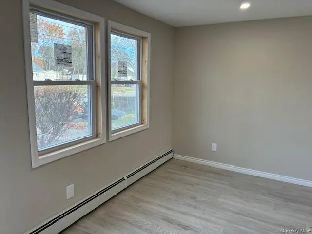 Spare room with a baseboard heating unit, light wood finished floors, and recessed lighting Spare room with a baseboard heating unit, light wood finished floors, and recessed lighting