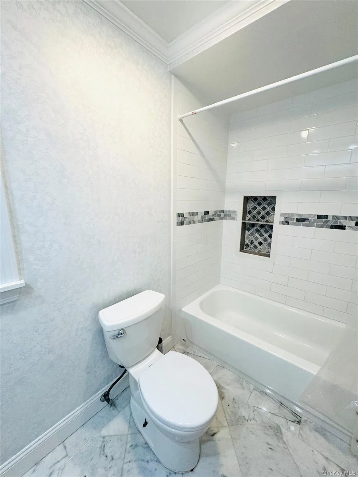 Bathroom with shower / tub combination, crown molding, and marble finish flooring Bathroom with shower / tub combination, crown molding, and marble finish flooring