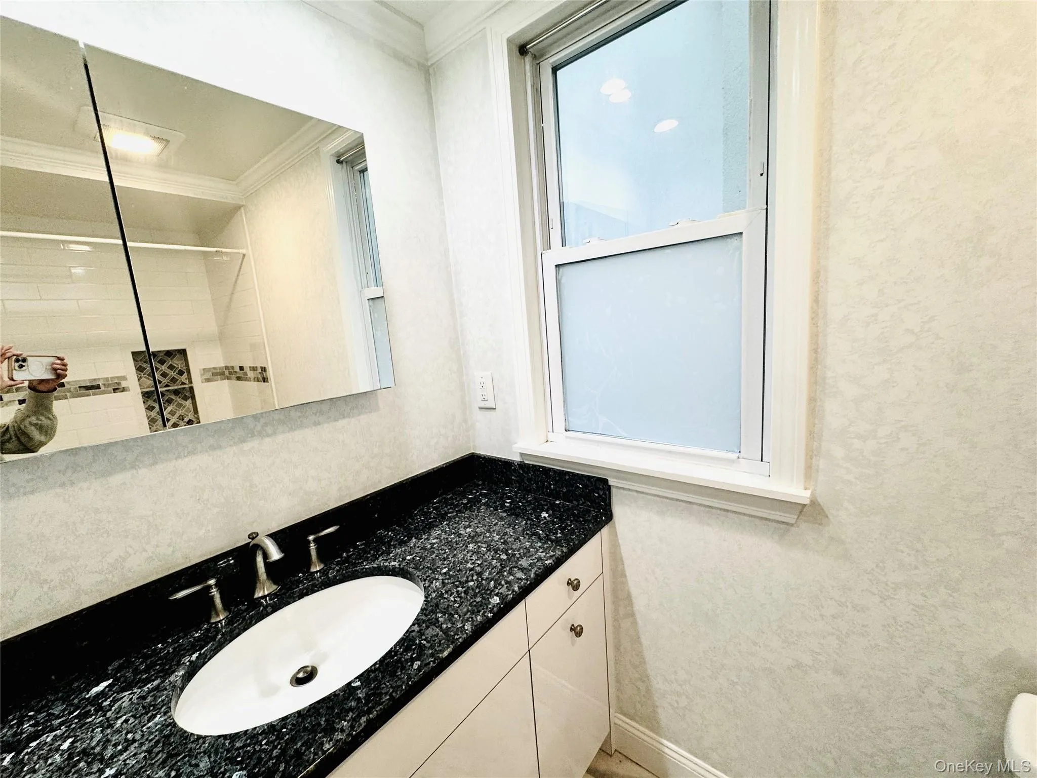 Full bath with vanity, a shower, and ornamental molding Full bath with vanity, a shower, and ornamental molding