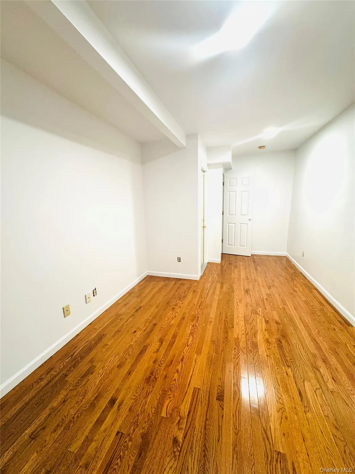 Spare room with baseboards and wood finished floors Spare room with baseboards and wood finished floors