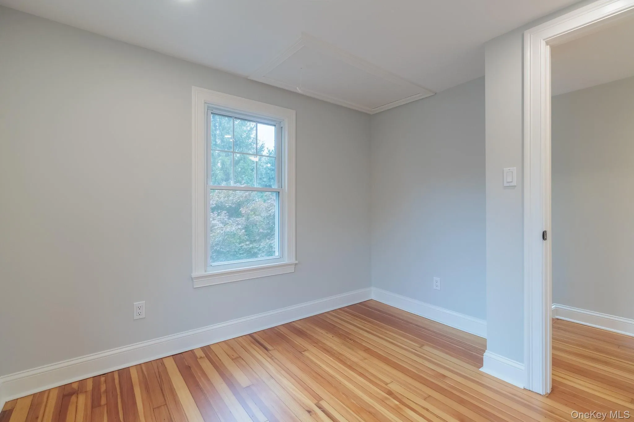 Spare room with attic access and light wood-style flooring Spare room with attic access and light wood-style flooring