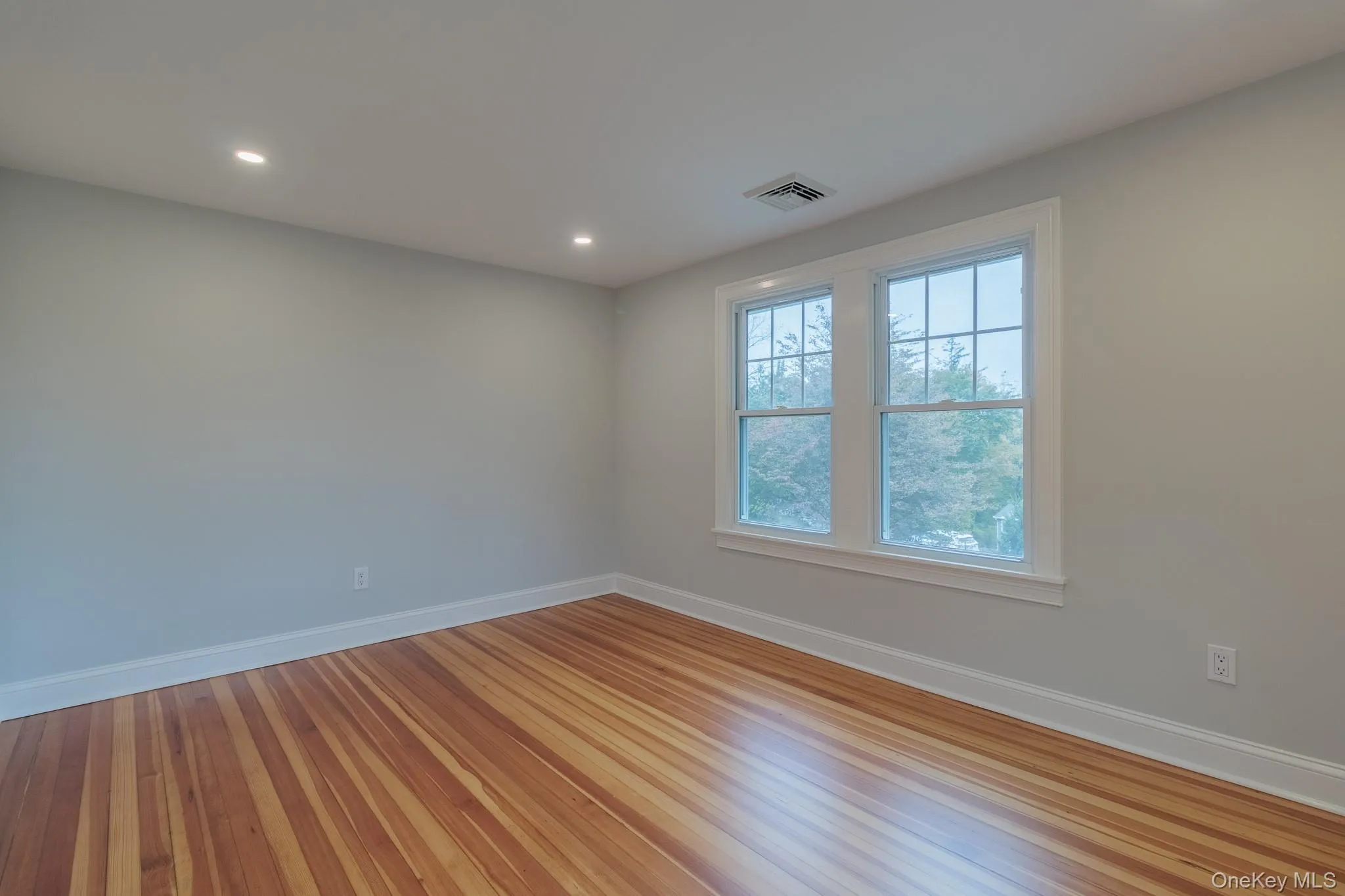 Empty room with wood finished floors and recessed lighting Empty room with wood finished floors and recessed lighting
