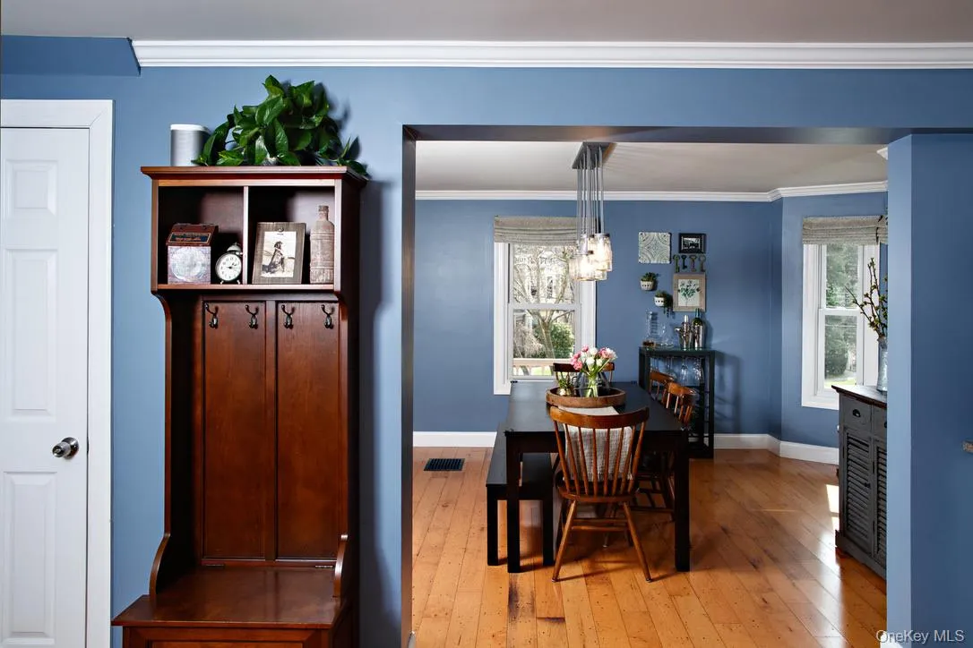 Dining space featuring light wood-style floors, crown molding, and a chandelier Dining space featuring light wood-style floors, crown molding, and a chandelier