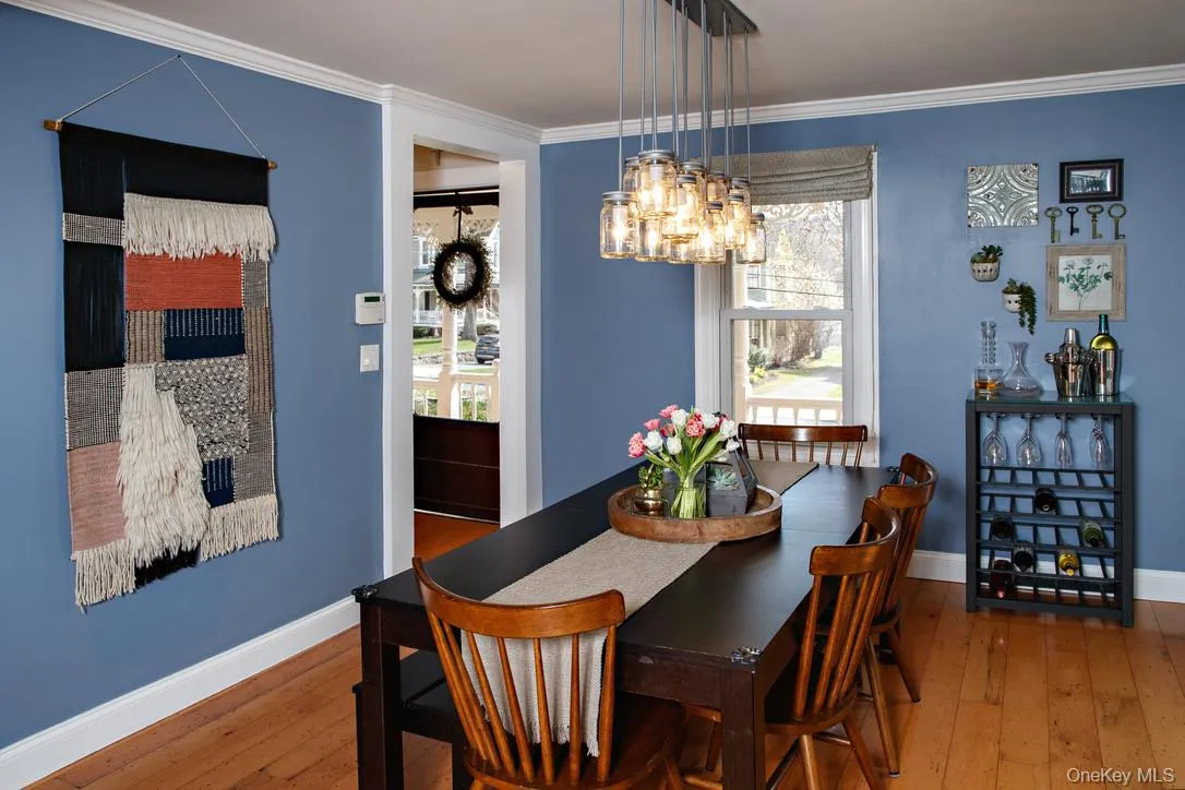 Dining area with ornamental molding, hardwood / wood-style floors, and a chandelier Dining area with ornamental molding, hardwood / wood-style floors, and a chandelier