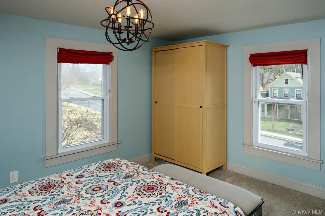 Carpeted bedroom with baseboards and a chandelier Carpeted bedroom with baseboards and a chandelier